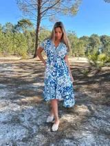 Vestido midi de seda con estampado floral en tonos azul y blanco, escote en V y mangas cortas.