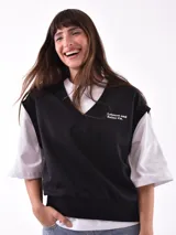 Chaleco negro con escote en V y bordado con la frase "Leisure and Relax Co." en el pecho.