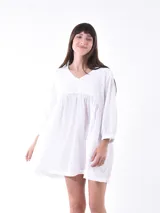 Vestido corto blanco con escote en V y mangas 3/4.