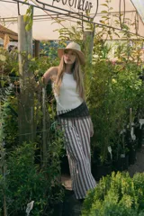 Pantalón largo de simil lino a rayas verticales color marrón y blanco, con cintura alta y bolsillos laterales.