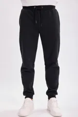 Pantalón deportivo tipo jogger color negro, con cintura elástica ajustable con cordón.