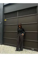 Pantalón palazzo negro de tiro alto con cinturón y corte holgado.