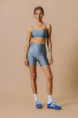 Calza corta tiro alto de cintura ancha con elástico fino en la parte superior. Tejido suave de alta elasticidad con un leve brillo satinado y estampado geométrico.