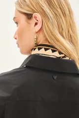 Camisa beige de poplin amplia, con botones laterales para abotonar de forma cruzada.