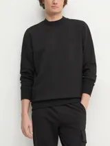 Buzo negro de cuello redondo, marca Calvin Klein Jeans. Confeccionado en tejido interlock suave de mezcla de algodón, poliéster y elastano. Presenta puños y dobladillo con punto canalé y monograma de Calvin Klein bordado tonal en el pecho.