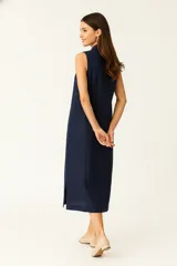 Vestido midi de lino color crudo, sin mangas, con cuello camisa y abotonadura frontal completa.