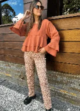 Blusa color ladrillo con corte a la cintura y volados. Mangas largas acampanadas.