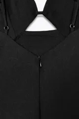Vestido midi negro confeccionado en lino. Presenta escote pico, tirantes finos ajustables, abertura en el delantero, cierre trasero con cremallera oculta y bajo con abertura.
