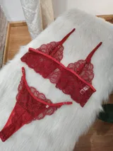 Conjunto de lencería de dos piezas color rojo, compuesto por un bralette de encaje floral con tirantes finos ajustables y una tanga a juego con bordes festoneados.
