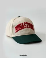 Gorra de béisbol de dos tonos, con visera curva y copa estructurada. Tiene bordado frontal en alto relieve con el texto "RONASTUDIO SOUTHAMERICAN LEAGUE".