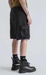 Bermuda negra de corte recto con bolsillos laterales y cinturón con hebilla metálica.