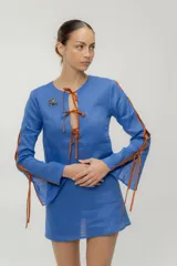 Vestido corto azul con escote en V y lazos marrones en mangas y escote.