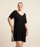 Vestido corto negro de viscosa con elastano, cuello en V con detalle de punto blanco y recorte lateral blanco.