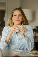 Pijama de dos piezas confeccionado en algodón estampado con diseño floral en tonos celeste y blanco. La camisa es de manga larga con botones al frente y el pantalón es recto con cintura elástica.