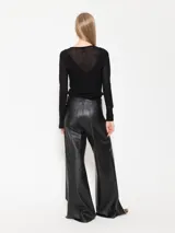 Pantalón de cuero овino de pata ancha, con cierre metálico y botón en la cintura.