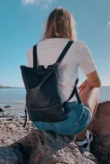 Mochila de cuero vacuno color negro, con diseño minimalista y strap ajustable.