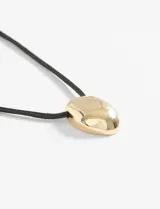 Collar con cordón negro y dije ovalado de acabado brillante.