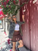 Musculosa blanca de algodón con cuello redondo y bordes en crochet color marrón.