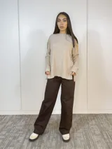 Pantalón de vestir marrón chocolate, de corte recto y tiro alto, con bolsillos laterales y cierre frontal con botón dorado.