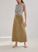 Falda midi de jean color beige, corte evasé, con bolsillos frontales y ruedo desflecado.