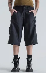 Pantalón negro con corte ancho, bolsillos laterales con solapa y detalle de cierre a la altura de la rodilla para convertirlo en short.