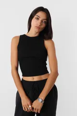 Crop top negro al cuerpo sin mangas de morley de algodón, con detalle de collareta en mangas y cuello, terminación de ruedo recto.