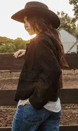 Chaqueta de cuero ovino italiano color beige, con cuello camisero, cierre con botones, dos bolsillos plaqué, corte recto relajado y largo a la cintura. Forro interior de algodón.