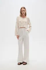 Pantalón blanco de lino, de corte recto y tiro alto, con bolsillos laterales.