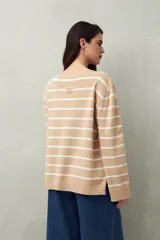 Sweater de punto a rayas horizontales color beige y blanco, con cuello bote y corte holgado.