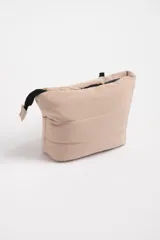 Necesser de poliéster color beige con diseño capitoneado y cierre superior con cremallera negra.