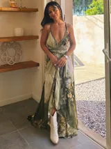 Vestido largo de tela fluida, color verde esmeralda con estampado abstracto en tonos turquesa y detalles dorados. Diseño asimétrico con un solo tirante tejido en el hombro.