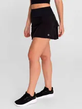Falda deportiva negra con calza interior, de secado rápido. Diseño acampanado con plisado en la parte trasera, pretina ancha con bolsillo con cierre y bolsillo interior en la calza.