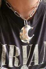 Collar plateado con cadena de eslabones grandes y dije de luna creciente texturizada. El dije está hecho de alpaca y bronce.