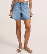 Bermuda de denim para mujer con cintura media y bajo deshilachado. Cuenta con trabillas en la cintura, cierre tradicional y bolsillos funcionales. Confeccionada en algodón con un toque de elastano.