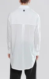 Camisa manga larga blanca de calce oversize confeccionada en textil fresco y liviano, con bolsillo ojal en delantero y cartera escondida.