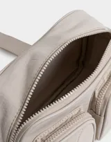 Bandolera celeste de tela deportiva acolchada con doble bolsillo con cierre, correa regulable y desmontable, manija superior, cierre superior y tag de metal.