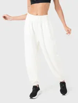 Pantalón de buzo blanco de tela suave, con bolsillos laterales y traseros, y elástico en los tobillos.