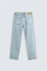 Pantalón de jean celeste de corte recto, con cinco bolsillos, efecto lavado y cierre frontal con botones.