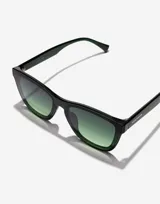 Gafas de sol Hawkers Downtown Max con montura cuadrada color verde oscuro y lentes degradadas en verde.