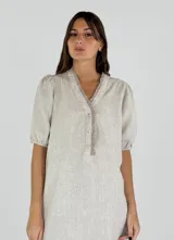 Vestido beige de lino con escote en V, mangas cortas abullonadas y cierre frontal con botones.