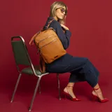 Mochila color marrón símil cuero con doble apertura superior con cierre. Incluye dos bolsillos al frente con cierres metálicos, asa rígida de mano y correa de galón. En la espalda correas de galón regulables.