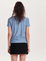 Camiseta celeste con textura calada, de manga corta y cuello redondo.