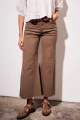Pantalón de jean color marrón, tiro medio, con corte wide leg y ruedo desflecado.