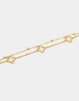 Pulsera plateada de doble cadena con bolitas y dijes de flor de cuatro pétalos esmaltados en negro.