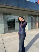 Top azul con mangas largas de tul y cuerpo de cuero sintético con drapeado horizontal en el busto.