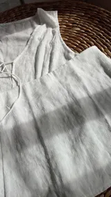 Conjunto blanco de top y short. El top es sin mangas, con escote en V y lazo ajustable en el centro. El short es de tiro alto y corte recto.