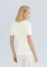 Camiseta verde claro de tela acanalada, con cuello alto y mangas cortas.