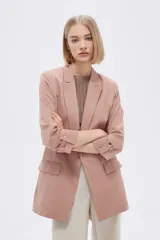Blazer color rosa viejo, de corte recto, con solapas y mangas 3/4 con botón decorativo.