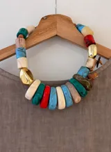 Collar corto con cuentas de resina de diferentes colores y formas, unidas por un cordón de cuero marrón.