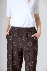 Conjunto de camisa y pantalón marrón con estampado de círculos blancos.